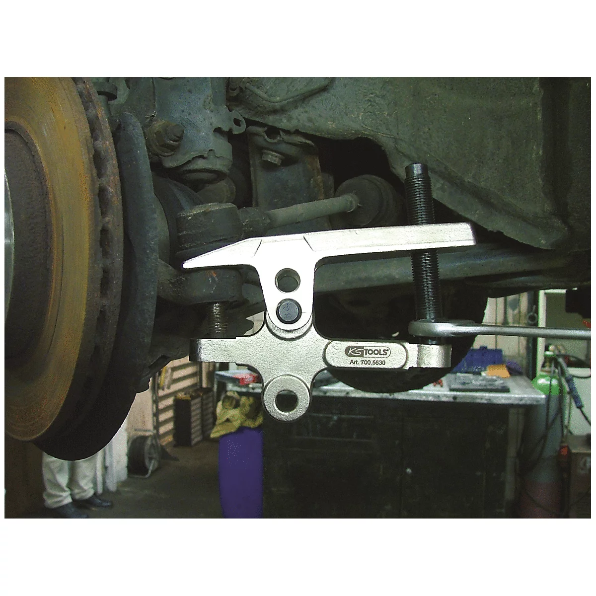 Nahaufnahme eines Werkzeugs, das an einem Autoreifen angebracht ist. Das Werkzeug ist silbern und hat die Aufschrift "KS TOOLS".